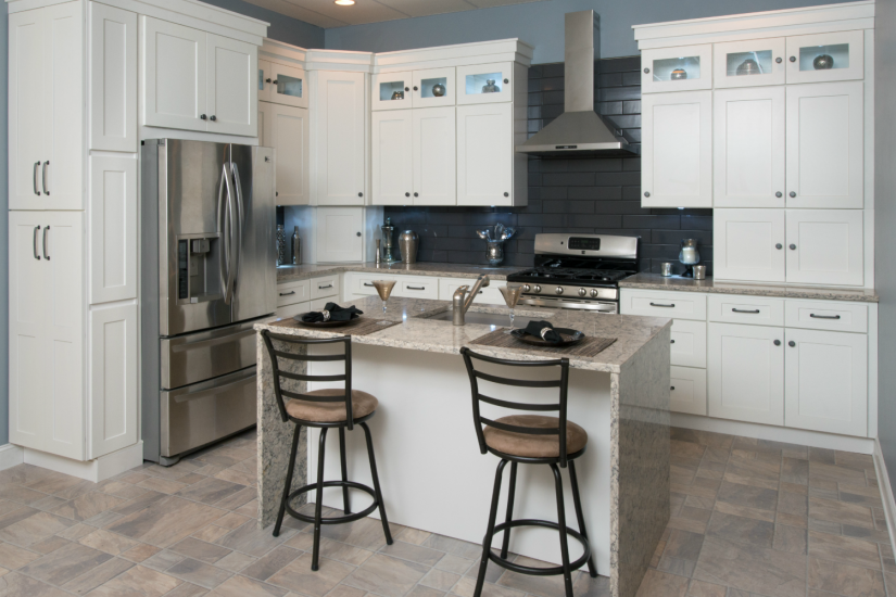 An L-shaped kitchen layout spreads appliances across two perpendicular walls and includes an island or kitchen cart in the center.